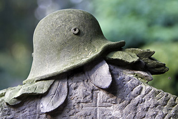 Grabstein mit Soldatenhelm am Volkstrauertag.